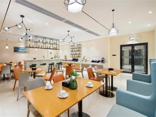 um restaurante com mesas e cadeiras e uma cafetaria em City Comfort Inn Haikou Xiuying District Wanda Plaza em Pin-lien