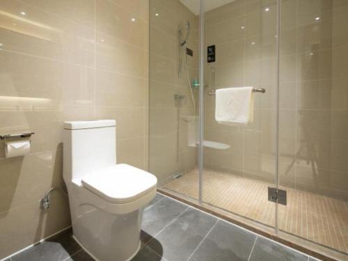 uma casa de banho com um WC e uma cabina de duche em vidro. em City Comfort Inn Haikou Xiuying District Wanda Plaza em Pin-lien