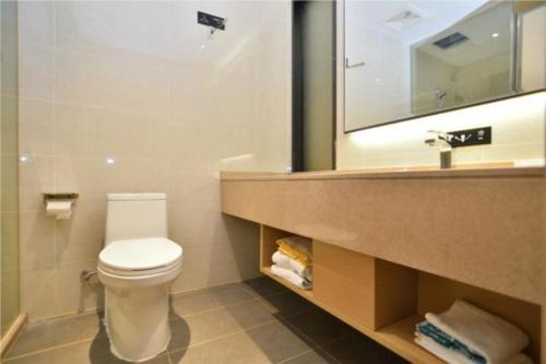 昆明的住宿－City Comfort Inn Kunming Xinluojiu Bay Guangju Road，一间带卫生间、水槽和镜子的浴室