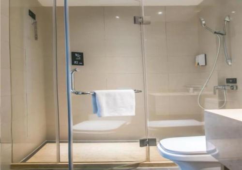 uma casa de banho com uma cabina de duche em vidro e um WC. em City Comfort Inn Zhuzhou Tianyuan em Zhuzhou