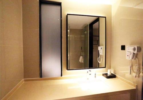 a bathroom with a sink and a large mirror at City Comfort Inn Shaoguan High-speed Railway Station Guanshaoyuan in Shaoguan