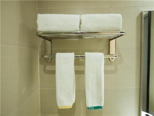 un baño con toallas blancas en un toallero. en City Comfort Inn Hotel Maoming Huazhou Wanda Plaza, en Dongshan