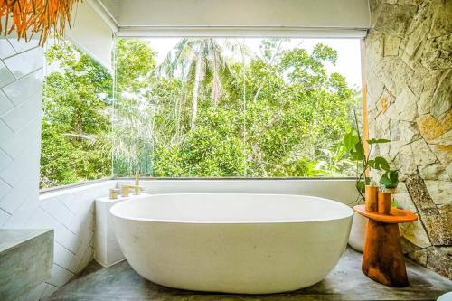 un bagno con vasca e ampia finestra di Serene 2BR Villa with Lush View 5 mins to Beach a Tanah Lot