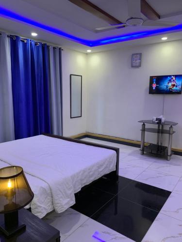 a room with a bed and a tv and blue lights at Sunrise Rest House in Islamabad