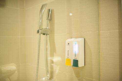 a soap dispenser on the wall of a shower at City Comfort Inn Changsha High Speed Railway Station in Yangtianhu