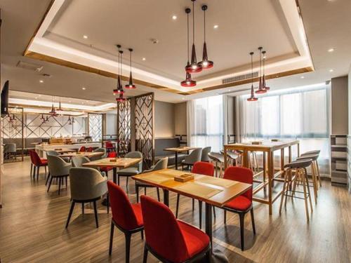 a restaurant with wooden tables and chairs and windows at Borrman Hotel Beihai Avenue High-speed Railway Station in Gaode