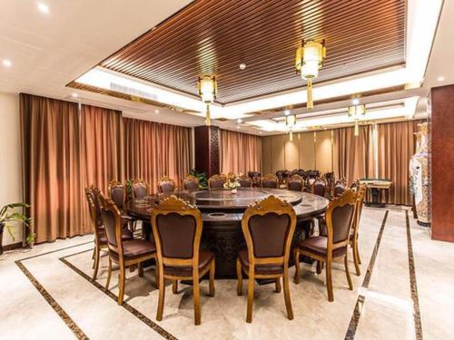 Borrman Hotel Beihai Avenue High-speed Railway Station في Gaode: قاعة اجتماعات مع طاولة وكراسي كبيرة