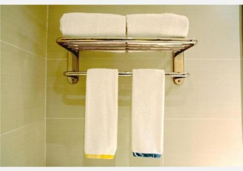 a towel rack with three towels on it in a bathroom at City Comfort Inn Shaoyang Xinning in Xinning