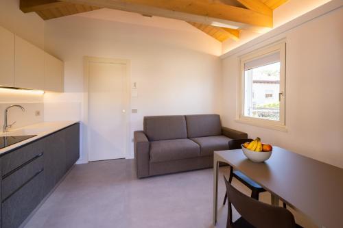 eine Küche und ein Wohnzimmer mit einem Sofa und einem Tisch in der Unterkunft Il Giardino Segreto in Cividale del Friuli