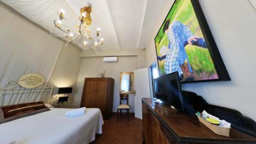 a bedroom with a bed and a flat screen tv at Hotel Utopía in Benalup Casas Viejas