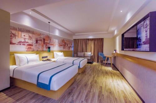 a hotel room with two beds and a flat screen tv at City Comfort Inn Guiyang Airport Future Ark in Guiyang