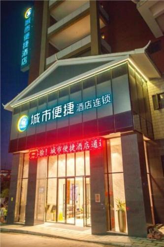 ein Gebäude mit Neonschildern auf der Vorderseite in der Unterkunft City Comfort Inn Huaihua Tunnel Bus Station in Tongdao