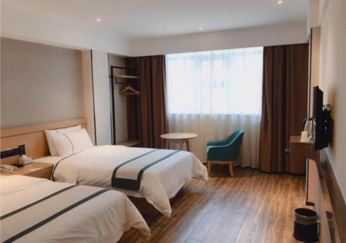 pokój hotelowy z 2 łóżkami i telewizorem w obiekcie City Comfort Inn Shaoyang Wugang w mieście Wugang
