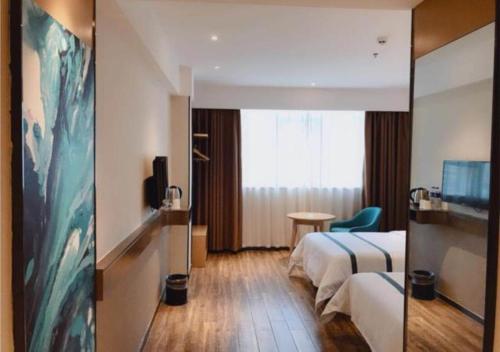 pokój hotelowy z łóżkiem i oknem w obiekcie City Comfort Inn Shaoyang Wugang w mieście Wugang