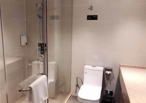 a white bathroom with a toilet and a shower at City Comfort Inn Shaoyang Wugang in Wugang