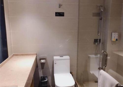 a bathroom with a white toilet and a shower at City Comfort Inn Shaoyang Wugang in Wugang