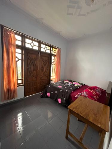 a bedroom with a bed and a window and a table at Good Karma Bromo Guesthouse in Bromo