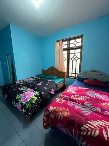 a bedroom with two beds and a window at Good Karma Bromo Guesthouse in Bromo