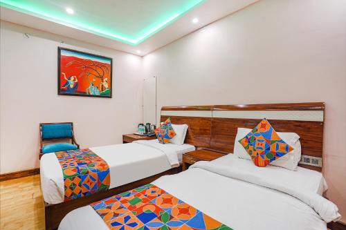 una camera con due letti e un dipinto sul muro di FabHotel Prime Stay inn I a Varanasi