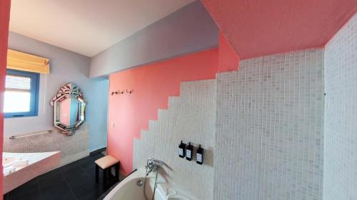 a bathroom with a tub and a red wall at Hotel Utopía in Benalup Casas Viejas