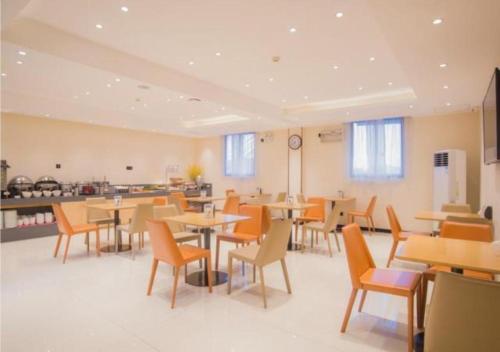 a dining room with tables and chairs and a clock at City Comfort Inn Liuzhou Longtan Park Ma'anshan Baiyun in Liuzhou