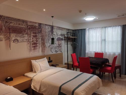 ein Hotelzimmer mit 2 Betten, einem Tisch und Stühlen in der Unterkunft City Comfort Inn Xiaogan Hubei Engineering College in Xiaogan