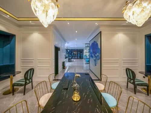 a dining room with a table and chairs and chandeliers at Xana Lite Hotelle Yan'an Baota Mountain in Yan'an
