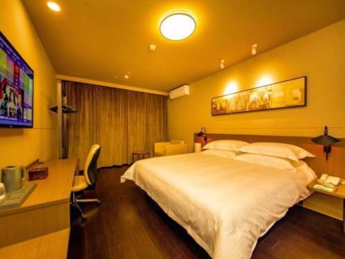 Pokój hotelowy z dużym łóżkiem i biurkiem w obiekcie Jinjiang Inn Select Shihezi East Ring Road w mieście Shihezi