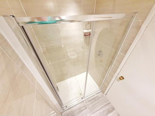 a shower with a glass door in a bathroom at Hidden Leicester&Covent Garden Gem in London