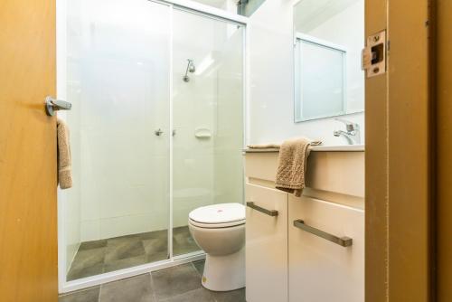 a bathroom with a shower and a toilet and a sink at Town Centre Motor Inn in Merimbula