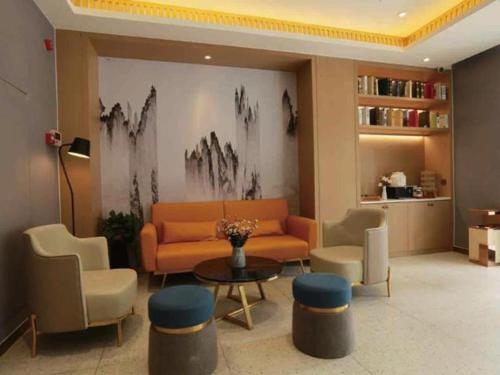 a lobby with a couch and chairs and a table at Jinjiang Inn Select Heze Wanxiang Plaza Guiling Road in Heze