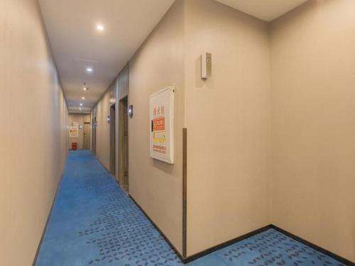 un pasillo con suelo azul en un edificio en 7 Days Premium Hotel Chongqing Jiefangbei No.1 Bridge Hongyadong en Chongqing