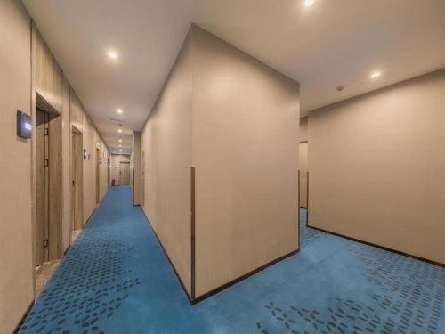 un pasillo con suelos azules y una fila de puertas en 7 Days Premium Hotel Chongqing Jiefangbei No.1 Bridge Hongyadong en Chongqing