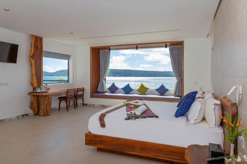 1 dormitorio con 1 cama grande y ventana grande en Pearl Beach Resort & Spa, en Koh Rong Sanloem