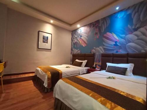 ein Hotelzimmer mit 2 Betten und einem Gemälde an der Wand in der Unterkunft PAI Hotel Nanchong Huaxi Normal University in Nanchong