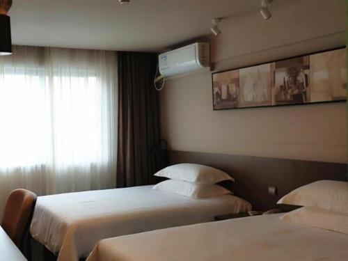 ein Hotelzimmer mit 2 Betten und einem Fenster in der Unterkunft Jinjiang Inn Select Xiamen International Airport in Linhou
