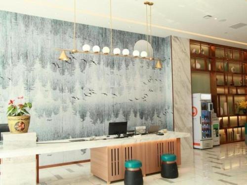 QiongtouにあるMagnotel Hotel Xiamen North Station Binhaiの壁画のあるロビー