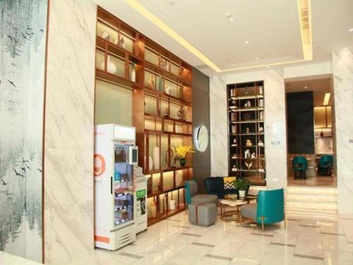 Magnotel Hotel Xiamen North Station Binhai في Qiongtou: لوبي فندق فيه ثلاجة وكراسي