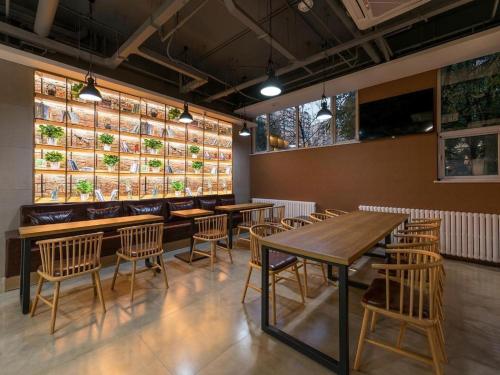ein Restaurant mit Holztischen und -stühlen in einem Zimmer in der Unterkunft James Joyce Coffetel Beijing South Station Xingong Metro Station Dayue Chunfengli in Peking