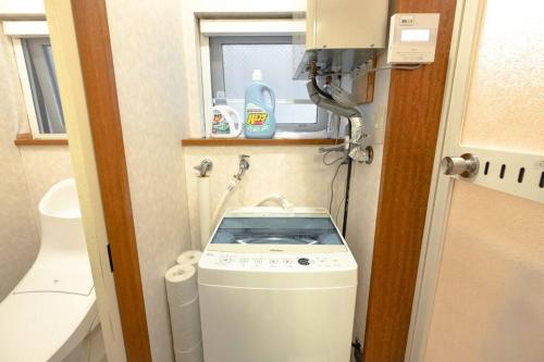 niewielka łazienka z pralką i oknem w obiekcie 函館ベイハウス-函館ベイエリアの観光に便利な 貸切住宅 w mieście Hakodate