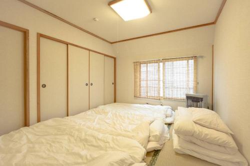 sypialnia z 2 dużymi białymi łóżkami w obiekcie 函館ベイハウス-函館ベイエリアの観光に便利な 貸切住宅 w mieście Hakodate
