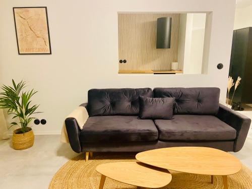 a living room with a leather couch and two tables at AK Apartments 2 in Warsaw