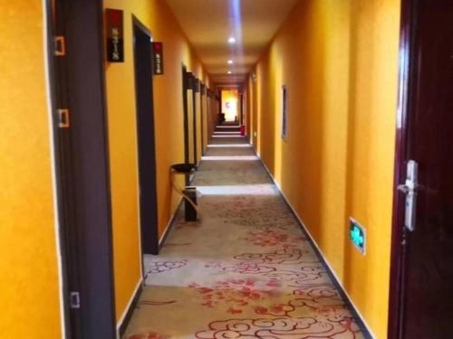 einen leeren Flur mit gelben Wänden und einem langen Gang in der Unterkunft Shell Hotel Nanyang High-Speed Railway Station Jiangying Airport Huayaocheng in Nanyang