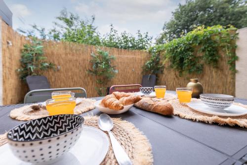 - une table avec de la nourriture, du jus d'orange et du pain dans l'établissement Villa Forlittoral, au Grau-dʼAgde