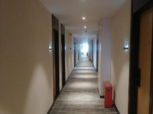 un couloir d'un immeuble de bureaux avec un long couloir dans l'établissement GreenTree Inn Express Guangxi Nanning Mingyang Avenue Nanning Airport, à Tanbai
