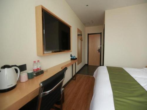 une chambre d'hôtel avec un lit et une télévision dans l'établissement GreenTree Inn Express Guangxi Nanning Mingyang Avenue Nanning Airport, à Tanbai