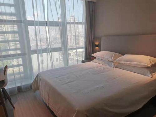 a bedroom with a large bed and a large window at Hanting Hotel Wenzhou Bus Station Avenue in Shanxia