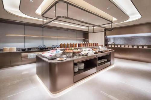 a restaurant kitchen with a buffet with food on it at Crystal Orange Hotel Wuxi Nanchang Street in Wuxi