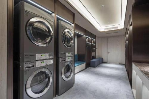 a laundry room with four washing machines in it at Crystal Orange Hotel Wuxi Nanchang Street in Wuxi