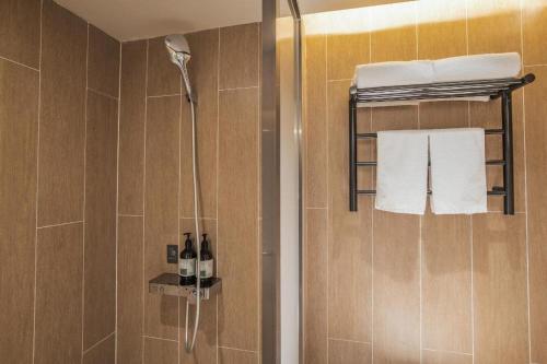 y baño con ducha, toallas y botellas. en JI Hotel Beijing Dazhongsi, en Beijing